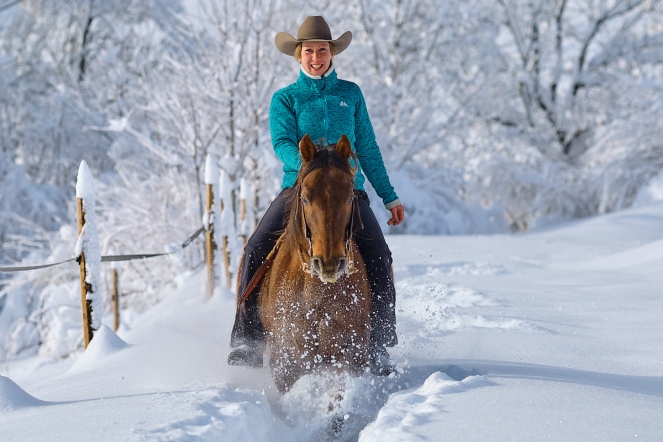 Evelyn mit ihrer Stute Mini galoppiert durch den Tiefschnee